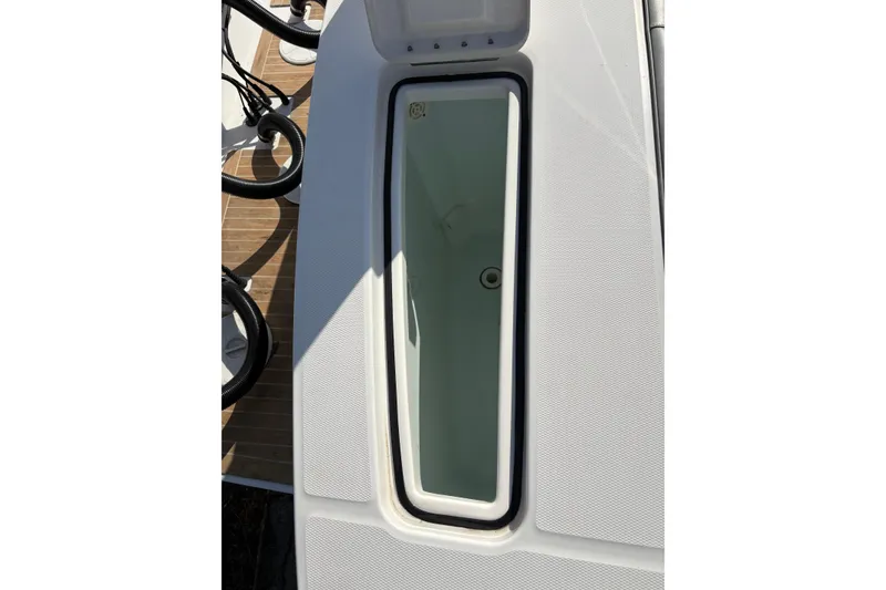 Slide: The Image of 2018 Regulator 34 Center Console boat storage compartment, open lid, and visible interior. - 28