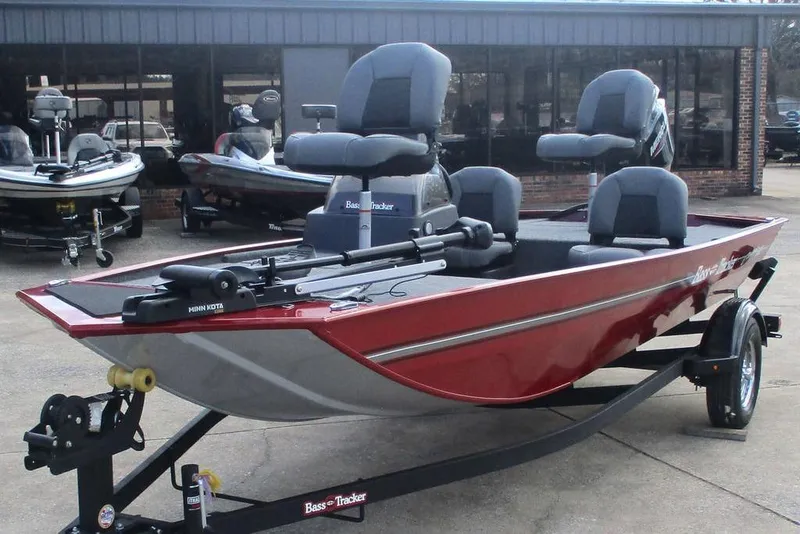 Slide: The Image of 2026 Tracker Bass Tracker Classic XL boat in showroom, red exterior, equipped with Minn Kota motor. - 8
