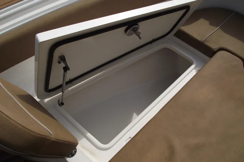 Slide: The Image of 2023 Sea Hunt Ultra 265 SE storage compartment with open lid and cushioned seating. - 12