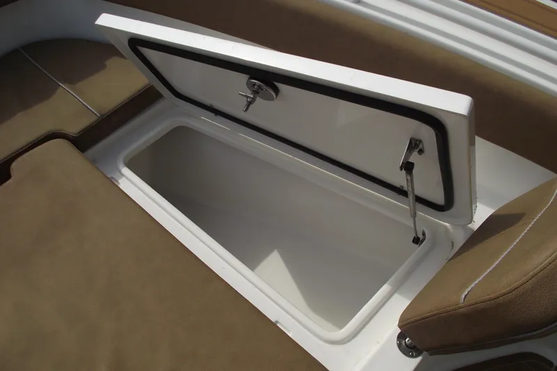 Slide: The Image of 2023 Sea Hunt Ultra 265 SE boat storage compartment with open lid and cushioned seating. - 13