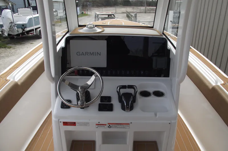 Slide: The Image of 2023 Sea Hunt Ultra 265 SE boat dashboard with Garmin navigation system and steering wheel. - 18