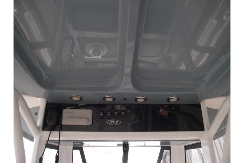 Slide: The Image of 2023 Sea Hunt Ultra 265 SE boat console with overhead lighting and equipment. - 19