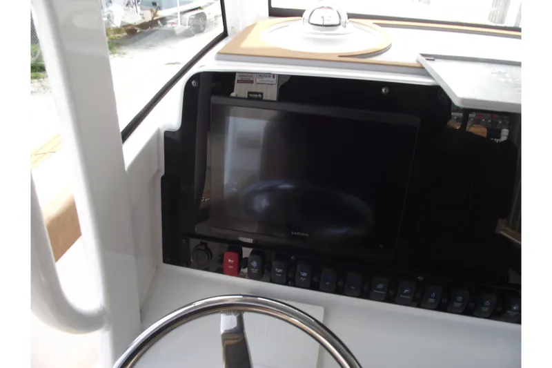 Slide: The Image of 2023 Sea Hunt Ultra 265 SE dashboard with Garmin display and steering wheel. - 21