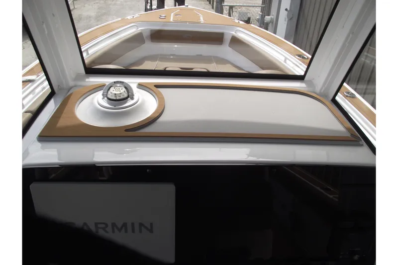 Slide: The Image of 2023 Sea Hunt Ultra 265 SE boat dashboard with compass and Garmin equipment. - 22