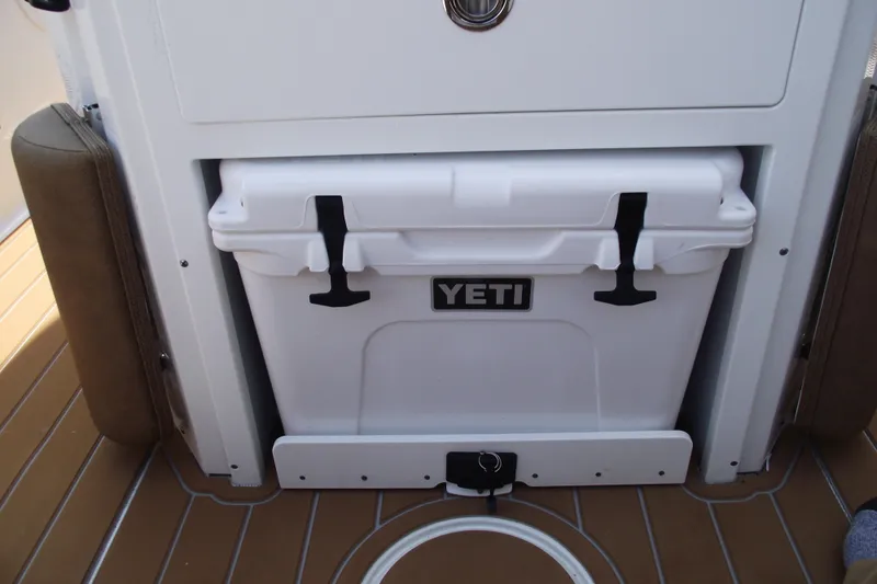Slide: The Image of YETI cooler on 2023 Sea Hunt Ultra 265 SE boat deck, secured with black latches. - 24
