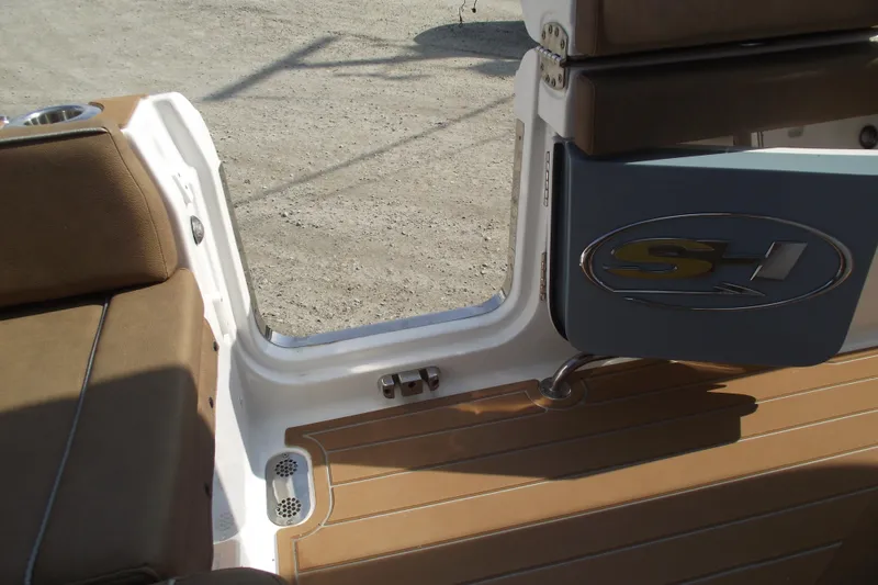 Slide: The Image of 2023 Sea Hunt Ultra 265 SE boat interior with brown seating and open door. - 27