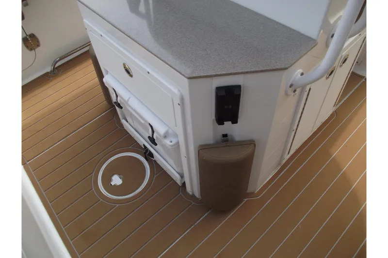 Slide: The Image of 2023 Sea Hunt Ultra 265 SE boat interior with tan deck and storage compartments. - 30
