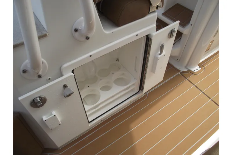 Slide: The Image of 2023 Sea Hunt Ultra 265 SE boat storage compartment with cup holders on deck. - 32