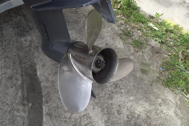 Slide: The Image of 2023 Sea Hunt Ultra 265 SE boat propeller on concrete and grass background. - 5