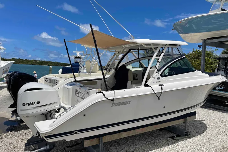 The Image of 2020 Pursuit DC 235 Dual Console boat with Yamaha engine, docked by the water. - 0