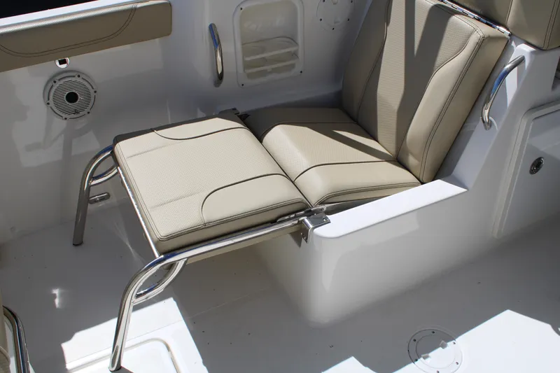 Slide: The Image of 2020 Pursuit DC 235 Dual Console boat seat with beige upholstery and stainless steel frame. - 17
