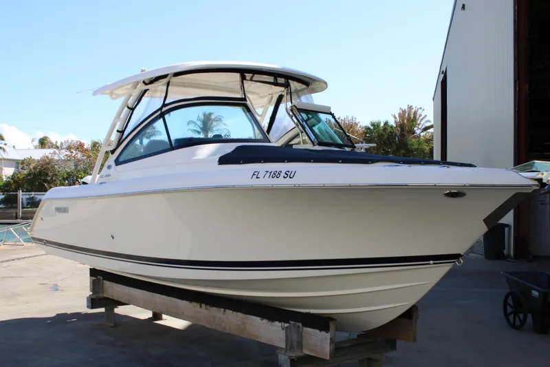 Slide: The Image of 2020 Pursuit DC 235 Dual Console boat on display at a marina. - 2