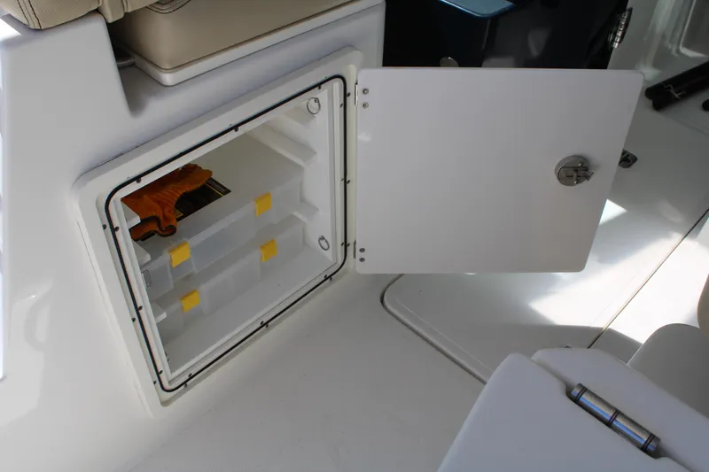 Slide: The Image of 2020 Pursuit DC 235 Dual Console boat bathroom with toilet and storage shelves. - 22