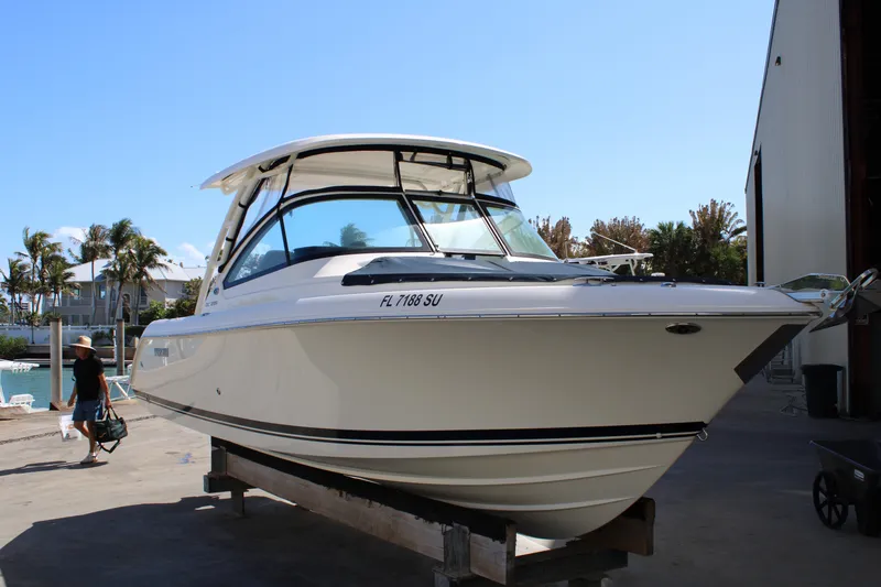Slide: The Image of 2020 Pursuit DC 235 Dual Console boat on dock, sunny day, palm trees in background. - 3