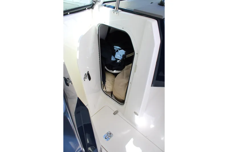 Slide: The Image of 2020 Pursuit DC 235 Dual Console storage compartment with open hatch and visible equipment. - 39