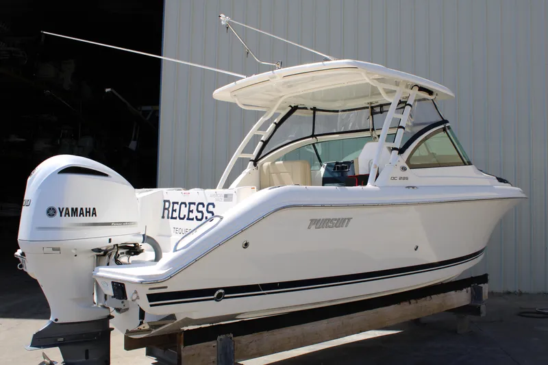 Slide: The Image of 2020 Pursuit DC 235 Dual Console boat with Yamaha engine, docked indoors. - 4