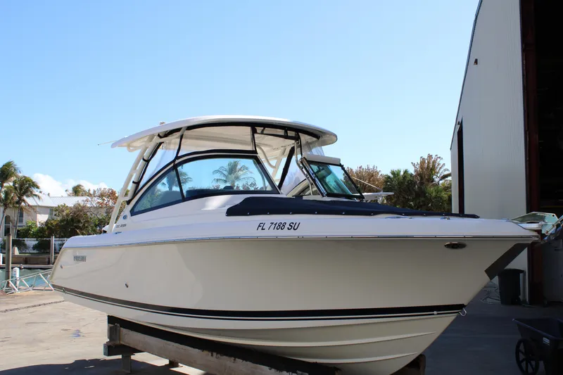 Slide: The Image of 2020 Pursuit DC 235 Dual Console boat docked outdoors on a sunny day. - 5