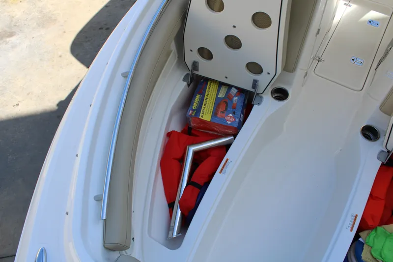 Slide: The Image of 2020 Pursuit DC 235 Dual Console boat storage with life jackets and safety gear. - 50