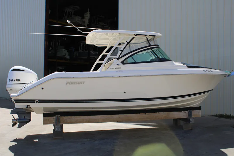 Slide: The Image of 2020 Pursuit DC 235 Dual Console boat with Yamaha engine, displayed outdoors. - 9