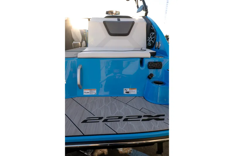 Slide: The Image of 2023 Yamaha Boats 222XD, blue deck with seating and speaker, rear view. - 15