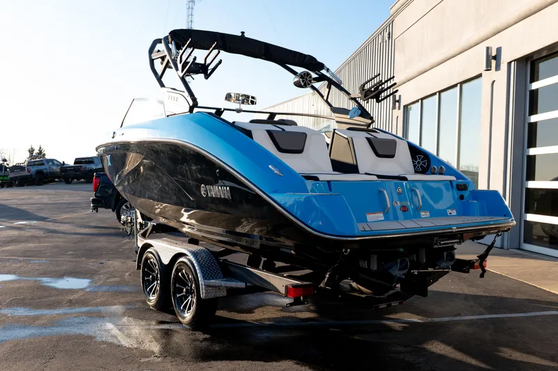 Slide: The Image of 2023 Yamaha Boats 222XD in blue, parked on a trailer outside a building. - 2