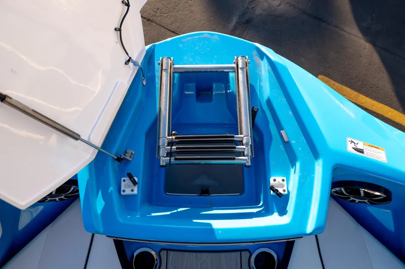 Slide: The Image of 2023 Yamaha Boats 222XD, blue deck with foldable ladder and storage compartment. - 27