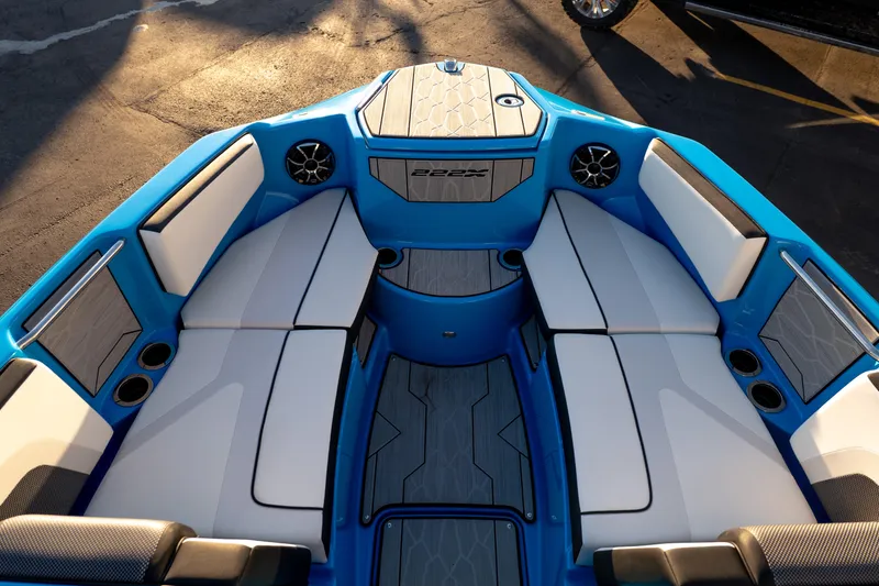 Slide: The Image of 2023 Yamaha Boats 222XD interior with blue and white seating, cup holders, and speakers. - 30