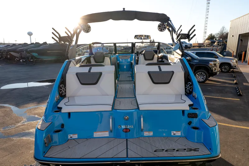 Slide: The Image of 2023 Yamaha Boats 222XD, blue exterior, rear view, parked in a marina. - 5