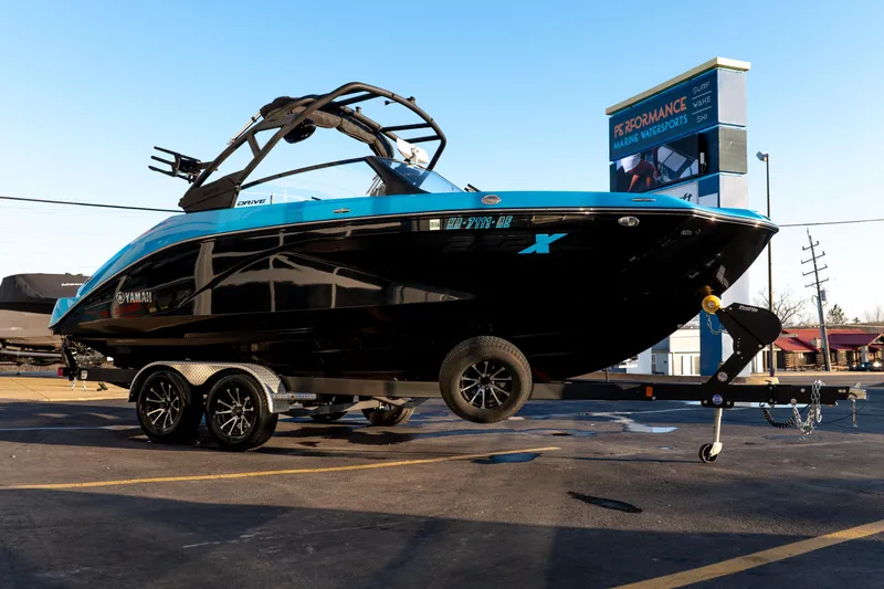Slide: The Image of 2023 Yamaha Boats 222XD in blue and black on a trailer at a dealership. - 6