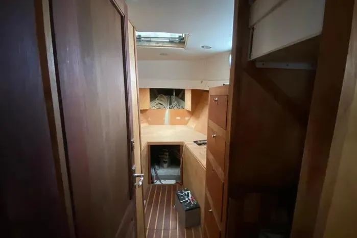 Slide: The Image of Interior of a 1966 Vanguard Bermudian Sloop, featuring wooden cabinetry and flooring. - 10