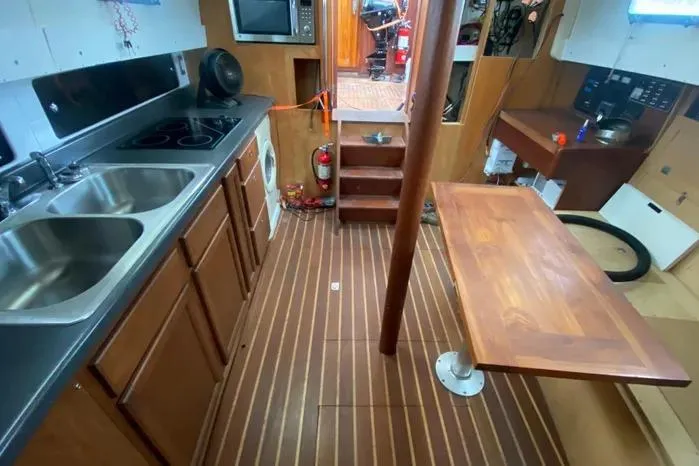 Slide: The Image of Interior of 1966 Vanguard Bermudian Sloop with kitchen and wooden table. - 11