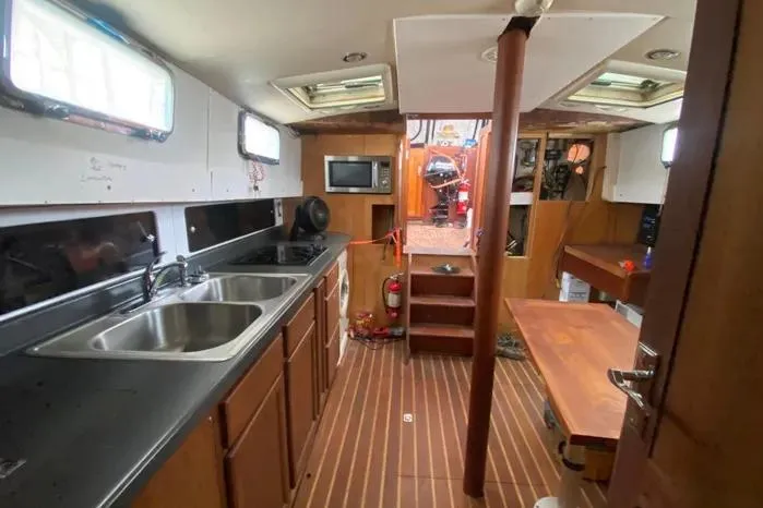 Slide: The Image of Interior of 1966 Vanguard Bermudian Sloop with kitchen and wooden flooring. - 14