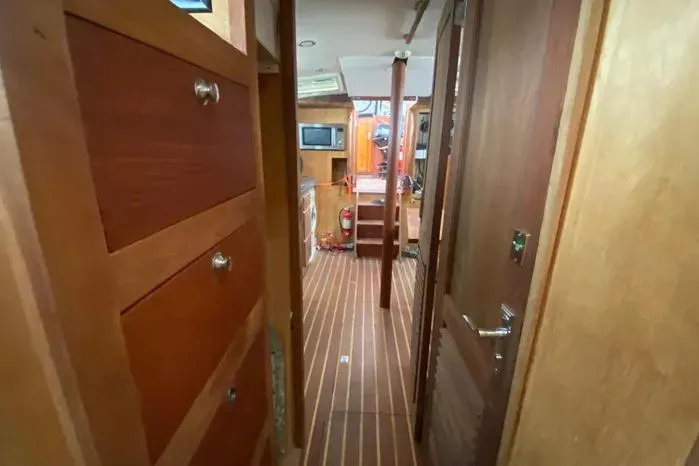 Slide: The Image of Interior of 1966 Vanguard Bermudian Sloop with wooden cabinetry and striped flooring. - 15