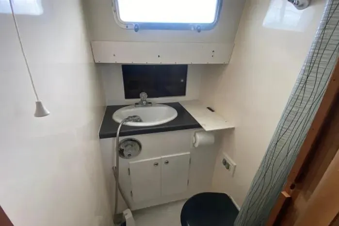 Slide: The Image of Compact bathroom in 1966 Vanguard Bermudian Sloop with sink, window, and storage cabinet. - 16