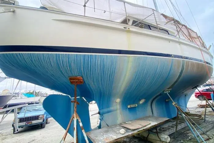 Slide: The Image of 1966 Vanguard Bermudian Sloop on dry dock, showcasing blue hull and keel. - 3