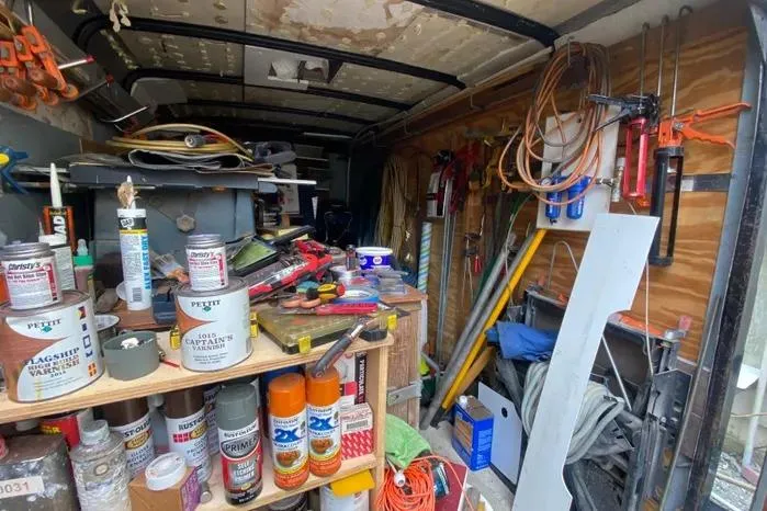 Slide: The Image of Workshop inside a 1966 Vanguard Bermudian Sloop, filled with tools, paint cans, and equipment. - 31