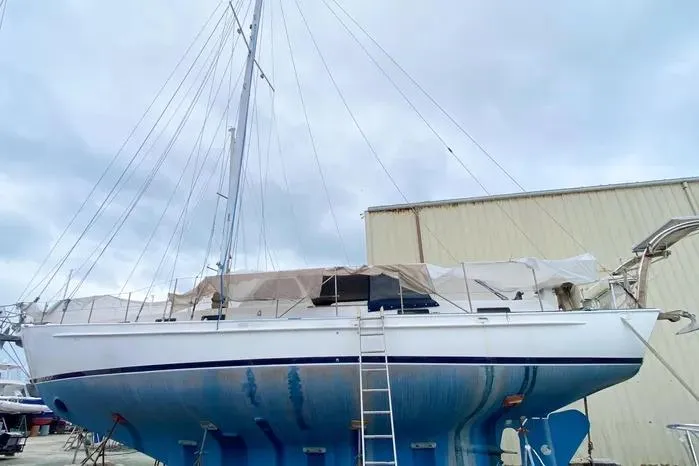 Slide: The Image of 1966 Vanguard Bermudian Sloop sailboat on land, with ladder and covered deck. - 4