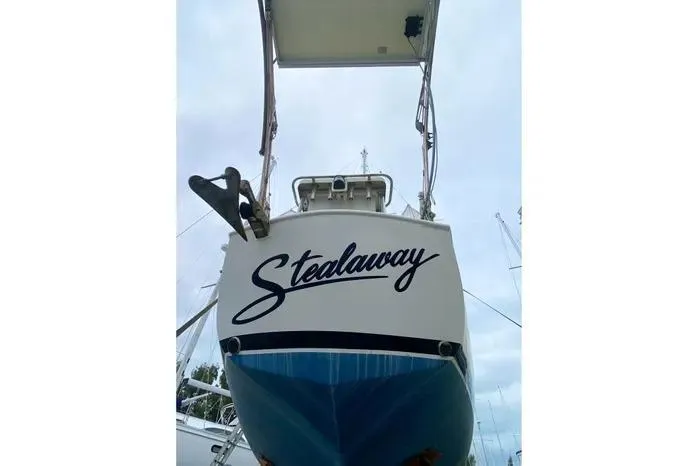 Slide: The Image of 1966 Vanguard Bermudian Sloop "Stealaway" with blue hull, docked under cloudy sky. - 5