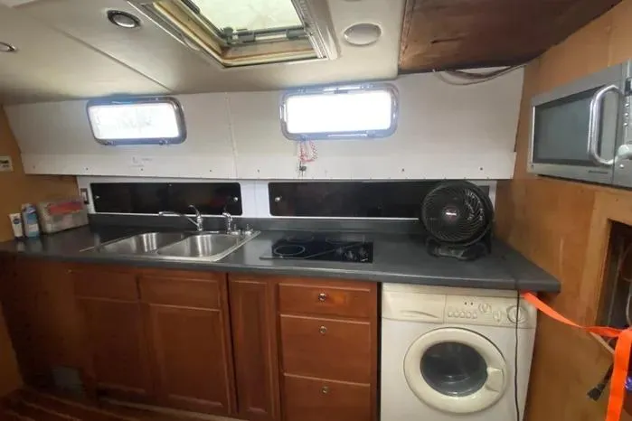 Slide: The Image of Interior of 1966 Vanguard Bermudian Sloop with kitchen, sink, stove, and washing machine. - 7