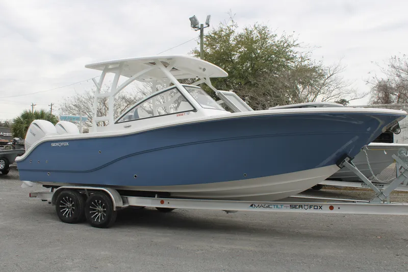 The Image of 2026 Sea Fox 268 Traveler boat on trailer, blue hull, parked outdoors. - 1