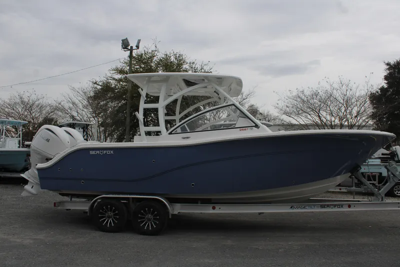 Slide: The Image of 2026 Sea Fox 268 Traveler boat on trailer, side view, blue hull, parked outdoors. - 2