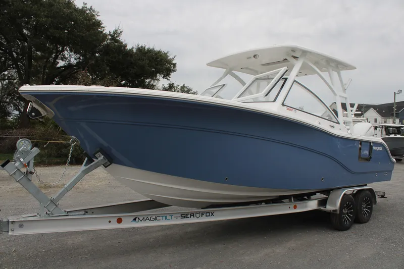 Slide: The Image of 2026 Sea Fox 268 Traveler boat on trailer, blue hull, parked outdoors. - 6