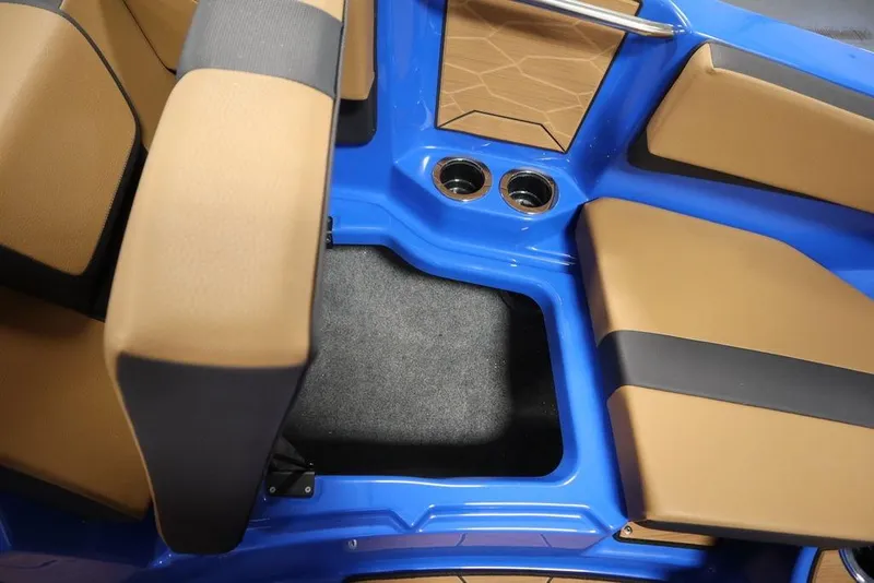 Slide: The Image of 2024 Yamaha Boats 222XE interior with tan and black seating, blue accents, and cup holders. - 12