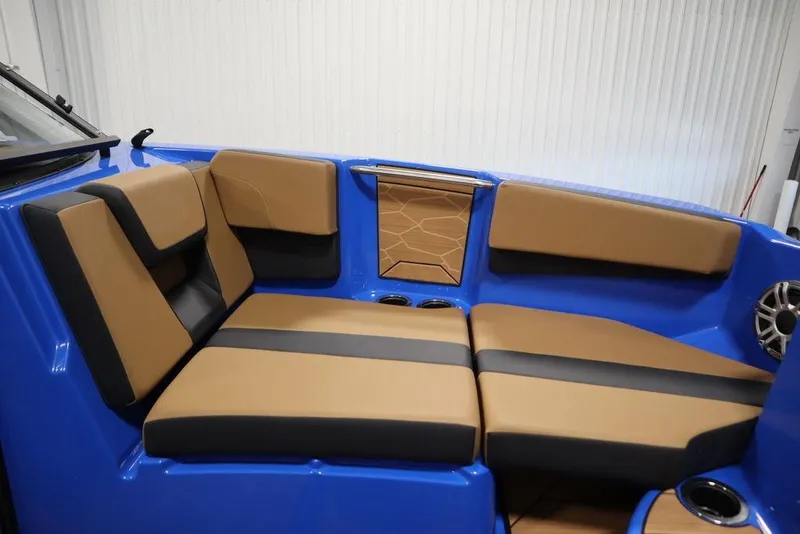 Slide: The Image of 2024 Yamaha Boats 222XE interior with tan and black seating, blue accents, and cup holders. - 15