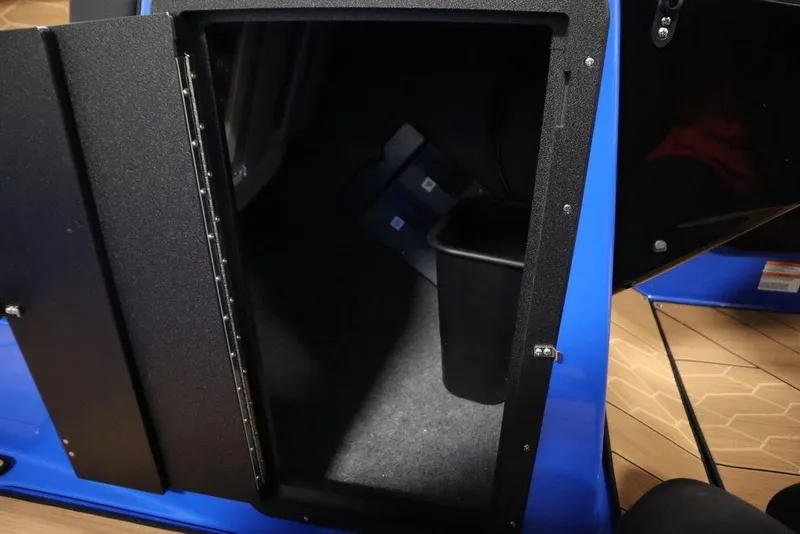 Slide: The Image of 2024 Yamaha Boats 222XE storage compartment with black interior and blue exterior. - 17