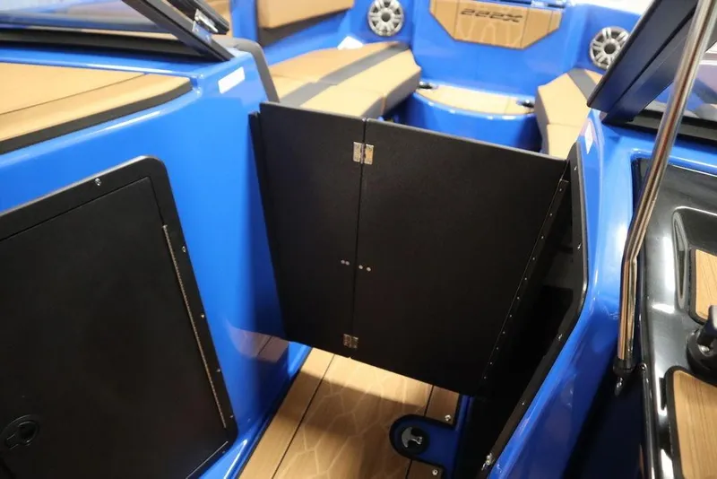 Slide: The Image of 2024 Yamaha Boats 222XE interior with blue and tan accents, open storage compartment. - 19