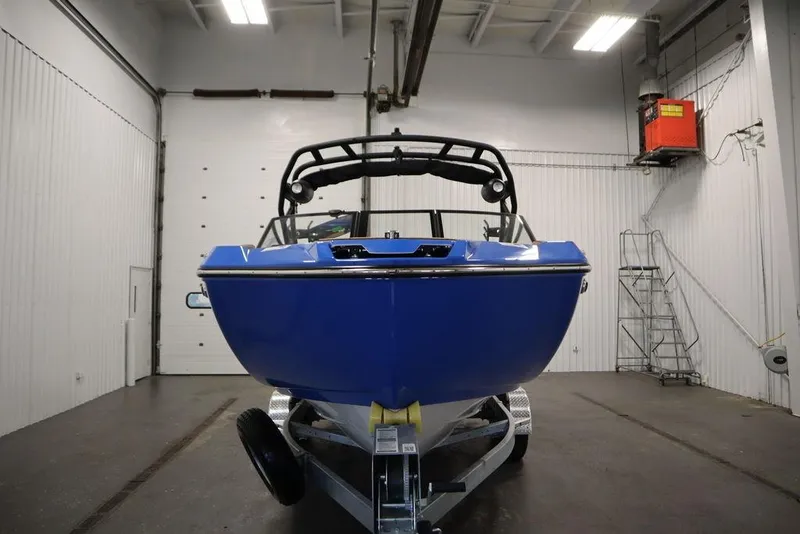 Slide: The Image of 2024 Yamaha Boats 222XE in a garage, showcasing sleek blue design and modern features. - 2