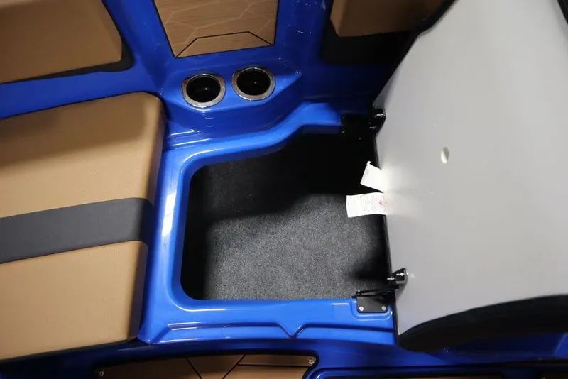 Slide: The Image of 2024 Yamaha Boats 222XE interior storage compartment with blue trim and cup holders. - 20