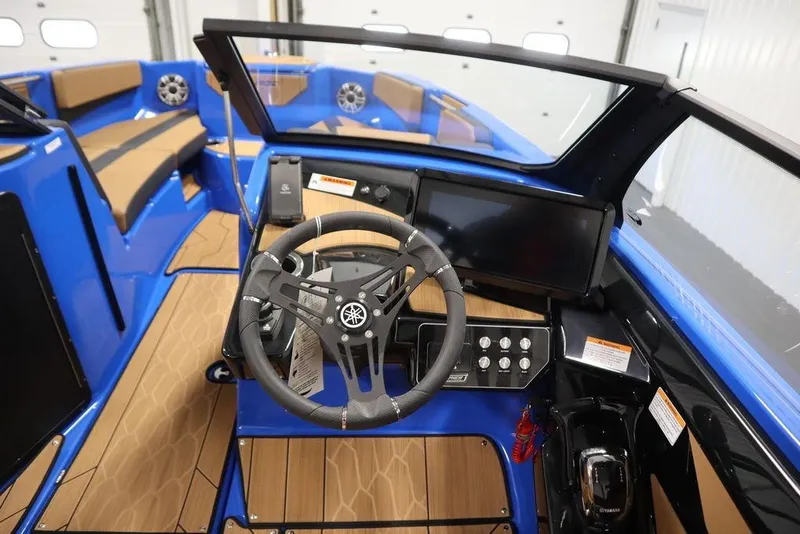 Slide: The Image of 2024 Yamaha Boats 222XE cockpit with steering wheel, dashboard, and seating in blue and tan. - 22