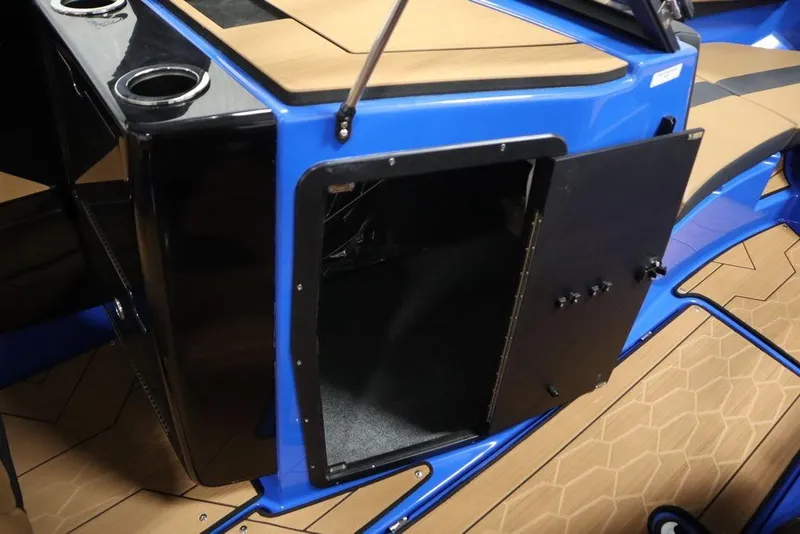 Slide: The Image of 2024 Yamaha Boats 222XE interior storage compartment with open door, featuring sleek blue and tan design. - 36